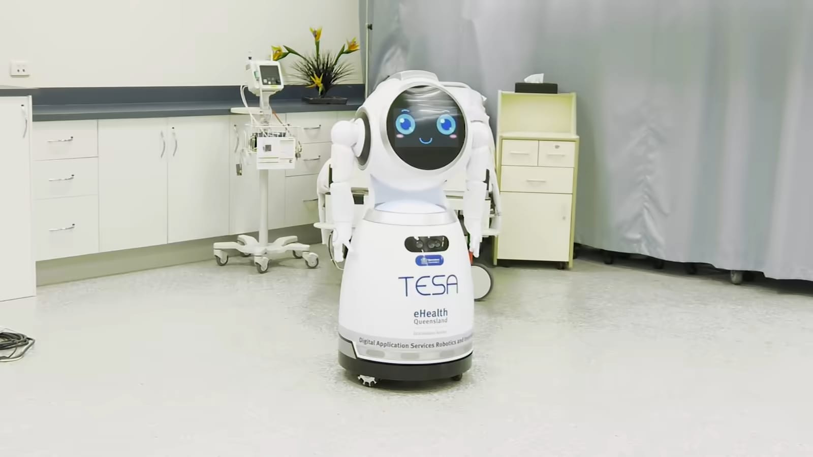 Robot CRUZR stoji v bolniški sobi ob medicinski opremi.